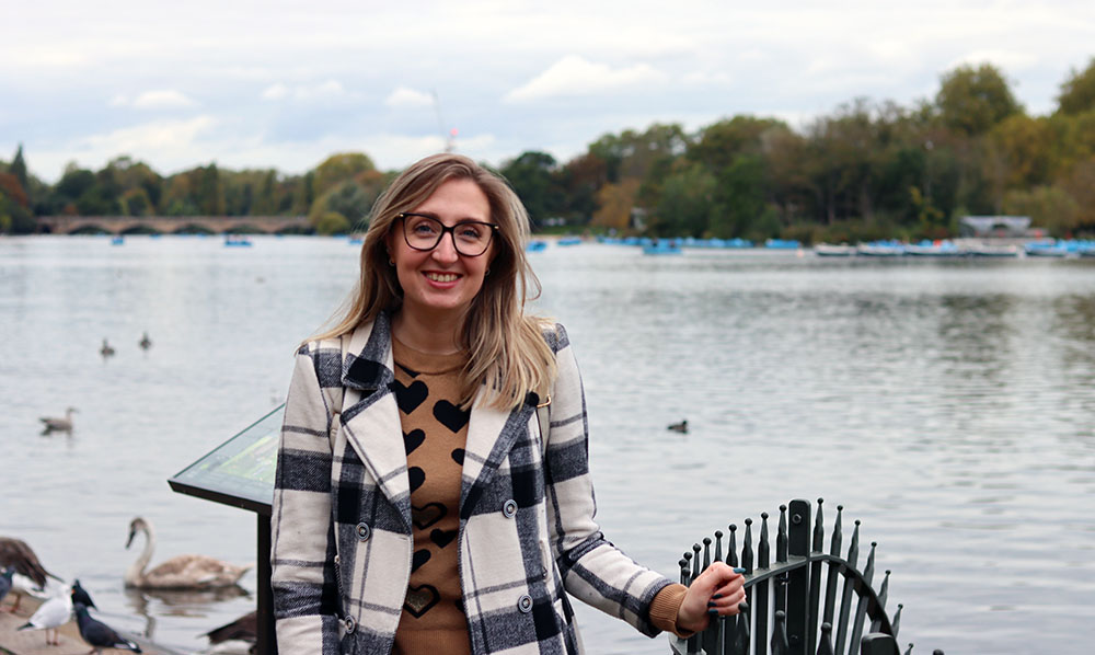 woman posing in front of lake at Hyde Park with ducks