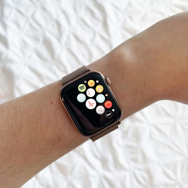 rose gold apple watch on wrist with multiple apps displayed, focused on the ECG app