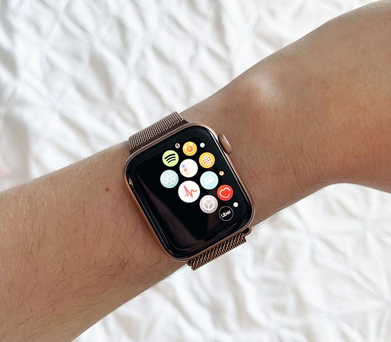 rose gold apple watch on wrist with multiple apps displayed, focused on the ECG app