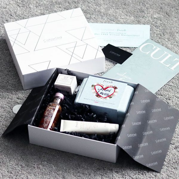 A Cohorted-branded beauty box opened up with various skincare products neatly displayed inside