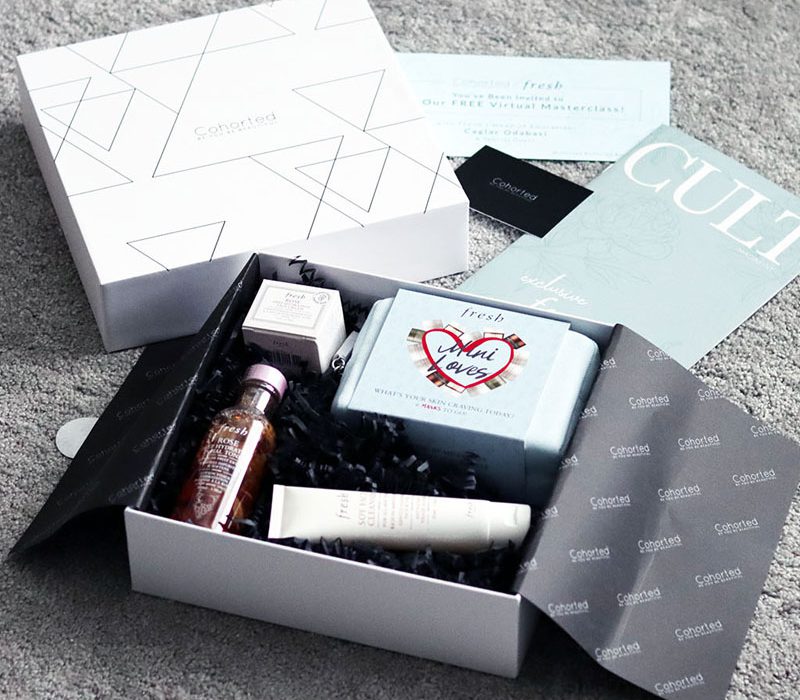 A Cohorted-branded beauty box opened up with various skincare products neatly displayed inside