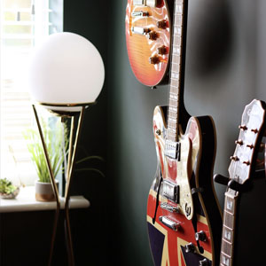 a dark green wall with a guitar hung on it with a union jack design
